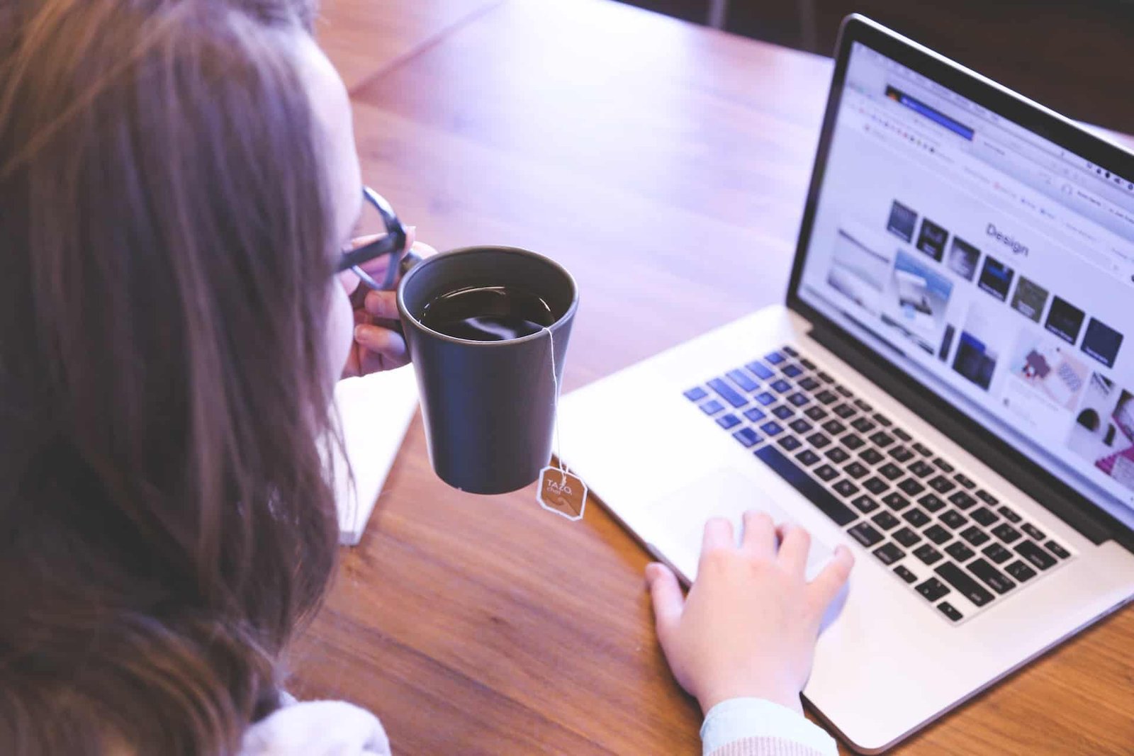 A woman drinking coffee while admiring the reliability of her web hosting services