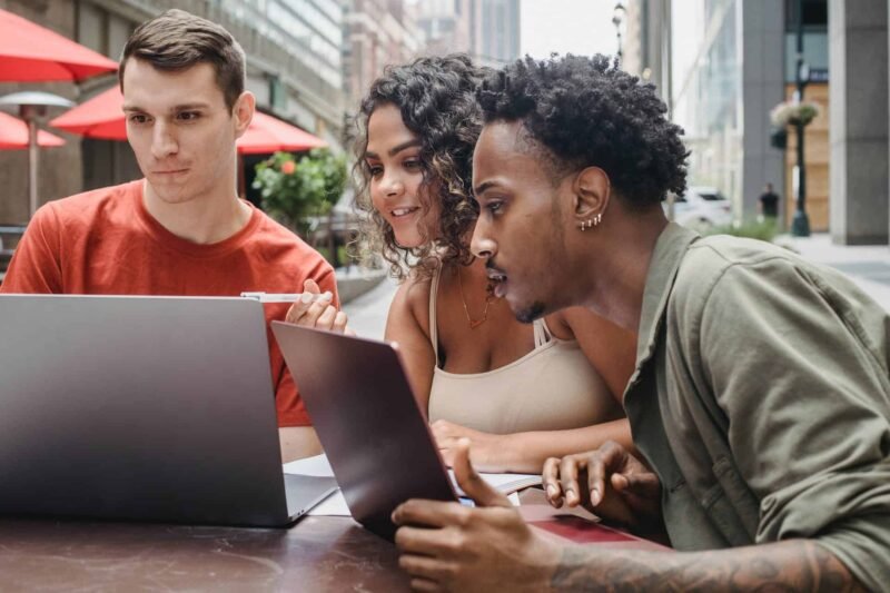 A web designer setting up his clients' web hosting while his clients look on