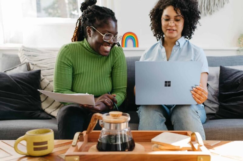 Two African American women excitedly admiring their new website