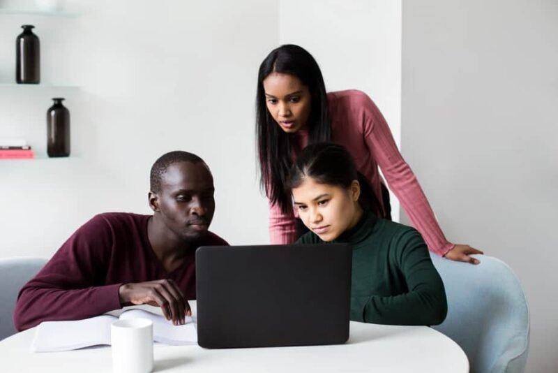 A black couple and Asian web designer examining a new website